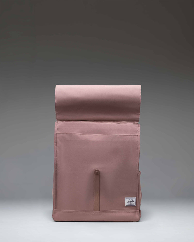 Herschel Supply Co. City Backpack in Ash Rose, showcasing a classic design with a single magnetic strap closure and a front storage sleeve.