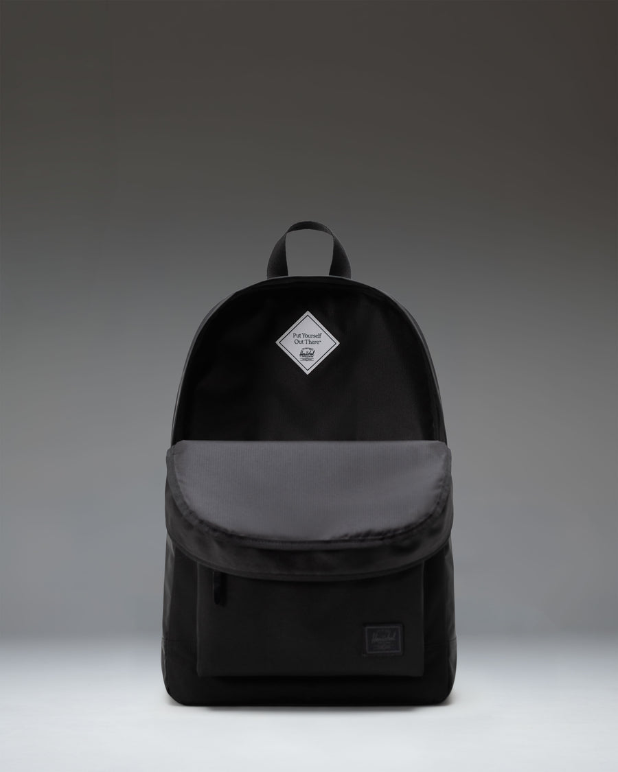 Classic Herschel Heritage Backpack in sleek black, featuring a zippered front pocket and the iconic woven label.