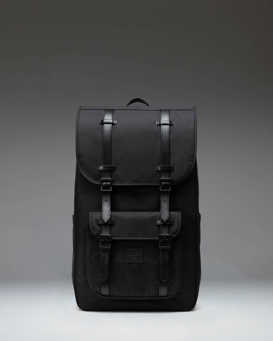 Black Herschel Little America Backpack featuring a classic mountaineering design with magnetic strap closures and a front pocket.