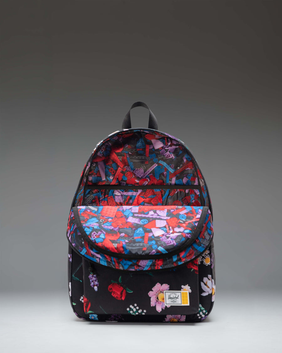 LEGO Herschel Classic XL Backpack in Falling Florals print featuring an all-over dark floral pattern with colorful Lego brick accents.