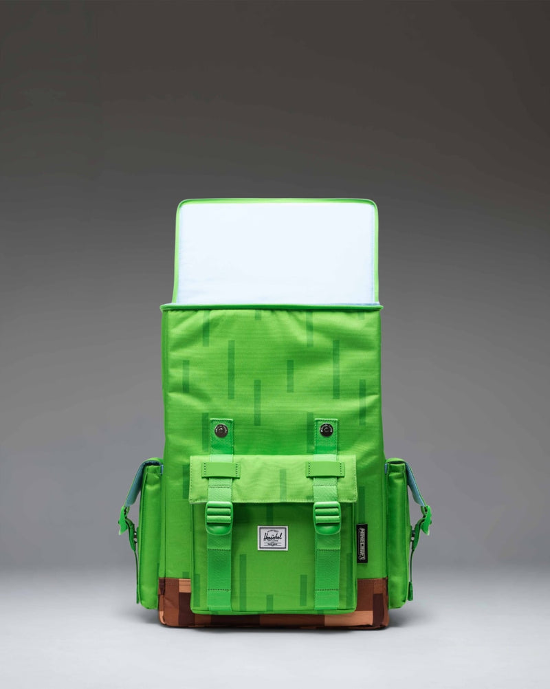 Minecraft Herschel Little America Cube Backpack in Grass Block color featuring a pixelated green and brown design with black straps.